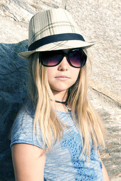 Long-haired girl in hat and sunglasses, portrait