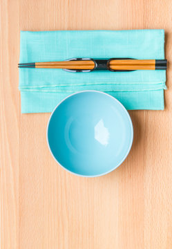 Empty Rice Bowl With Bamboo Chopsticks On Wooden Table.