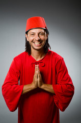 Man in red dress wearing fez hat