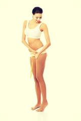 Female buttocks with a measurement tape.