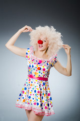 Clown with white wig against grey background