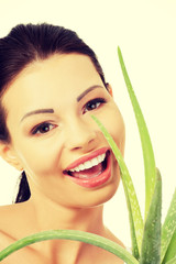 Young beautiful woman's face and aloe vera.
