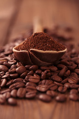 grated coffee in spoon on roasted coffee  beans background