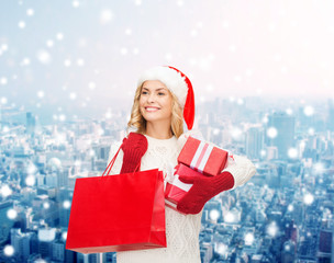 smiling young woman in santa helper hat with gifts