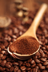 grated coffee in spoon on roasted coffee  beans background