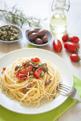 italian spaghetti pasta with cherry tomatoes, olives, capers and