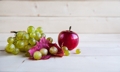 apples with grapes on wooden background