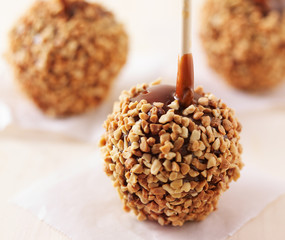 three caramel apples with nuts