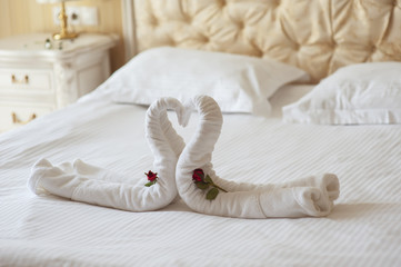 Fototapeta na wymiar decoration beds in the hotel two swans and heart of polotets