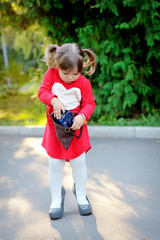 Fototapeta premium Little girl with handbag in park
