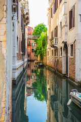 Obraz premium Narrow canal among old colorful brick houses in Venice
