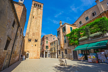 Narrow canal among old colorful brick houses in Venice