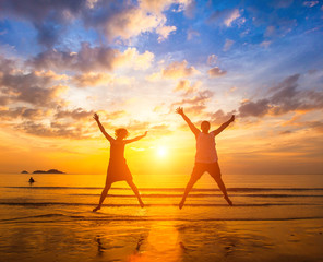 Couple in love jumping on the ocean beach .