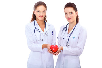 Fototapeta premium Two woman doctor holding a red heart, isolated on white