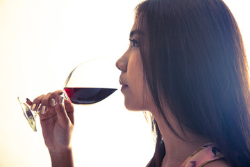 Beautiful Asian woman drink red wine