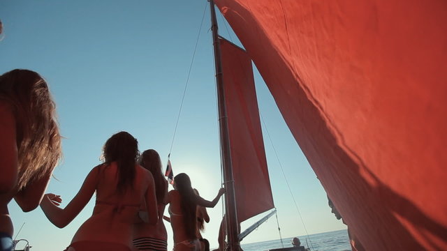 Girls in bikini and with a good figures having fun on a yacht