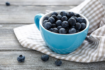 ripe blueberries in a blue cup