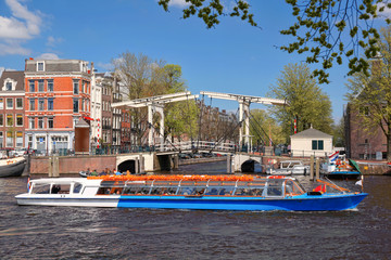 Fototapeta premium Amsterdam city with boats on canal in Holland