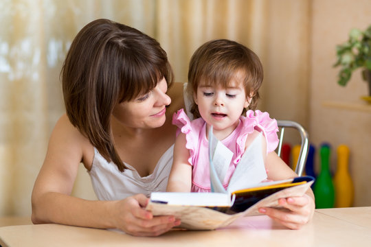 mother and kid girl read a book