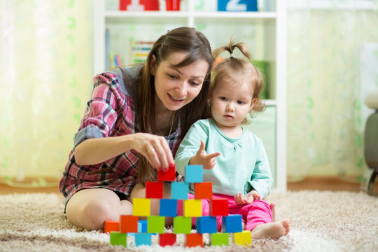 mother and her kid play with toys indoors