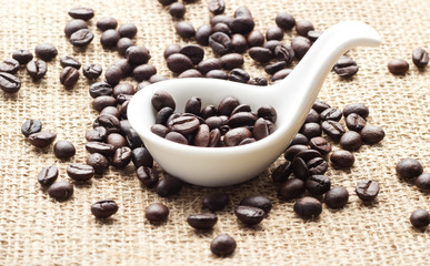 Coffee in spoon and sack background