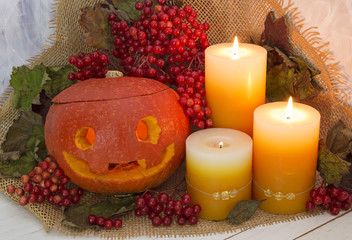 Carved pumpkin with lanterns and berries
