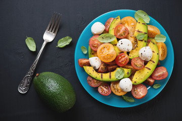 Vegetable salad with grilled avocado and cheese, view from above