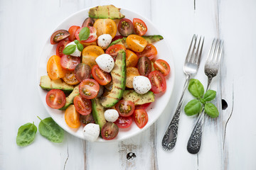 Salad with grilled avocado, tomatoes and mozzarella, above view