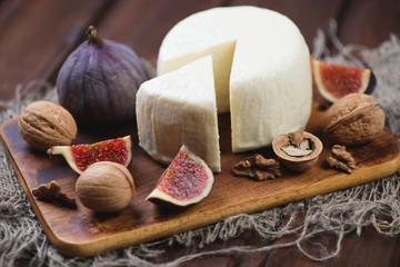 Fototapeta na wymiar Cheese, ripe figs and walnuts, close-up, horizontal shot