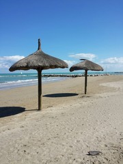 Spiaggia vuota con ombrelloni di paglia