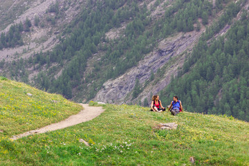 Coppia seduta su prato in montagna