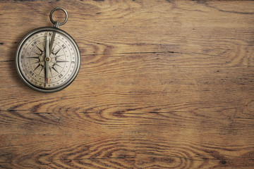 old compass on vintage wooden table top view
