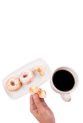 Female hand holding doughnuts with a mug of coffee