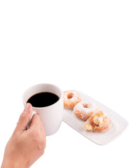 Female hand holding a mug of coffee with homemade doughnuts