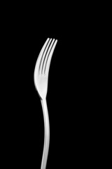 Stainless fork on black background with copy space.