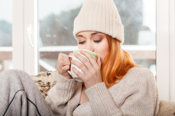 Woman wearing warm clothing and drinking hot drink