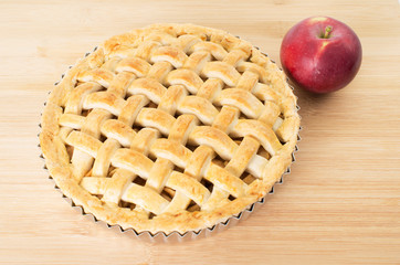 Baked apple pie against wooden background