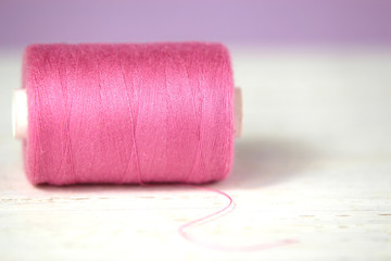 Pink thread on white and lilac background