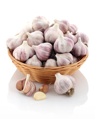 garlic in a wicker basket on a white background
