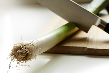 leek rod with knife on a wooden cutting board