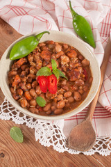 Homemade baked beans in a ceramic plate arranged on rustic woode