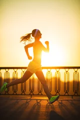 Abwaschbare Fototapete Joggen Laufende Frau. Läufer joggt bei Sonnenaufgang im Freien