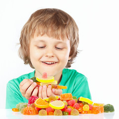 Little child with sweets and jelly candies on a white background
