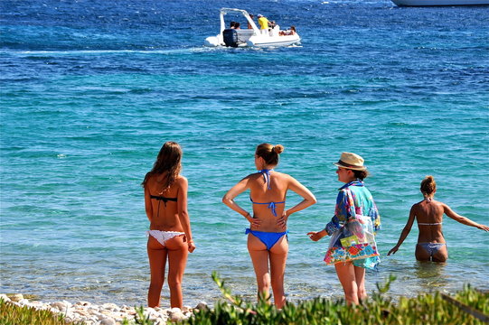 Frauen im Bikini warten auf die Jungs im Boot