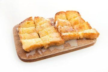 Bread toast and condensed milk on wooden plate