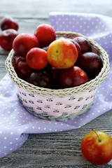 ripe plums in a round basket