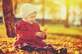 happy little child, baby girl laughing and playing in autumn
