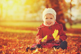 happy little child, baby girl laughing and playing in autumn
