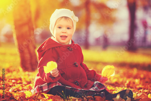happy little child, baby girl laughing and playing in autumn