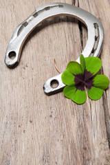 Horseshoe with a shamrock on old wooden